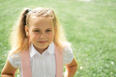 Portrait of smiling young woman sitting on field