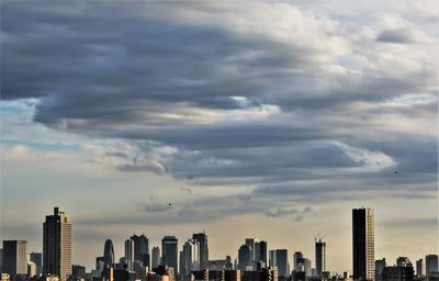 View of cityscape against cloudy sky