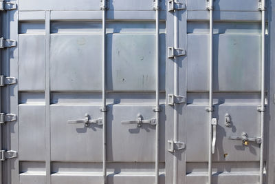 Detailed close up view on metal and steel surfaces on a silver cargo containter