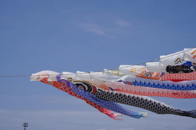 Low angle view of flags hanging against sky