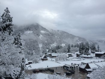 Scenic view of snow covered mountains against cloudy sky