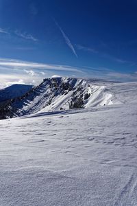 Scenic view of snowcapped mountains against blue sky