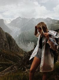 Woman standing on mountain against sky