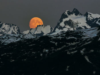 Panoramic view of the moon in-between alaskas mountain 