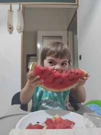 Portrait of girl with ice cream on table at home