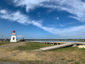 Lighthouse by sea against sky