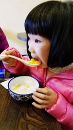 Close-up of girl eating food at home