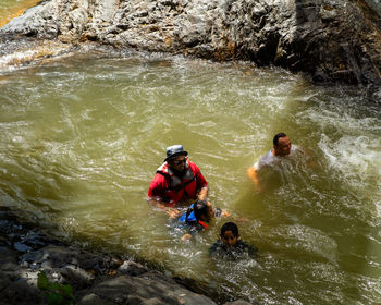 High angle view of people on rock by river