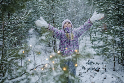 Woman standing on snow covered plants