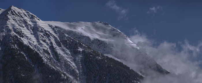 Low angle view of snowcapped mountain against sky