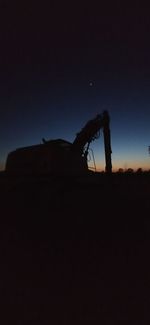 Silhouette of rocks on land against sky at sunset