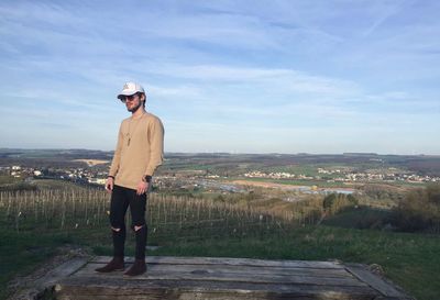 Portrait of man standing on landscape against sky