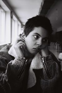 Portrait of young woman holding camera at home