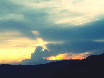 Scenic view of dramatic sky over silhouette landscape