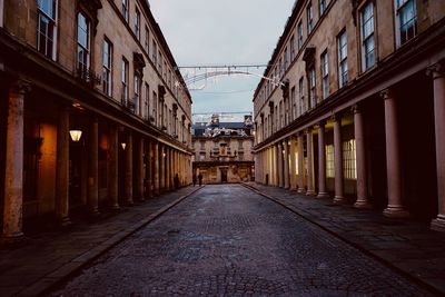 Empty alley amidst buildings in city