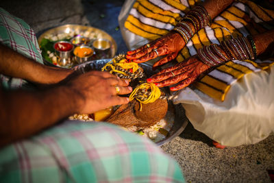 Low section of couple performing rituals during wedding ceremony