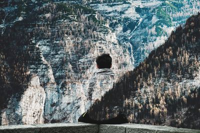 Rear view of woman standing by rock formation