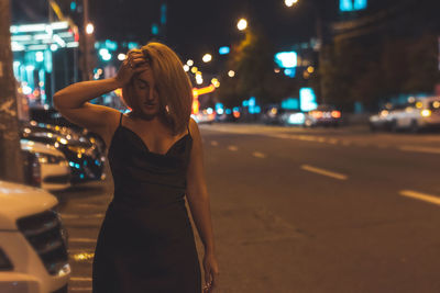 Woman standing on road at night