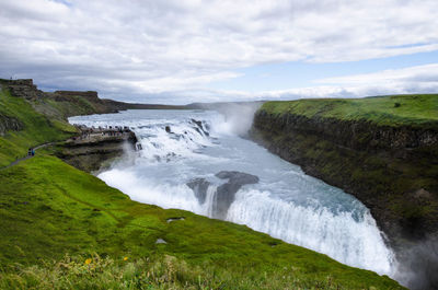 Scenic view of waterfall against sky