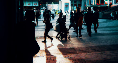 Silhouette people walking on street in city