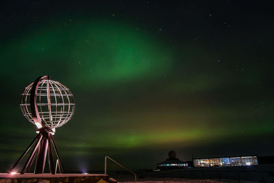 Low angle view of illuminated ferris wheel against sky at night