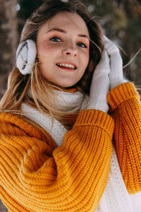 Teen blonde in a yellow sweater outside in winter. a teenage girl on a walk in winter clothes