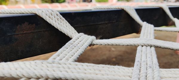Close-up of rope tied to woven cot