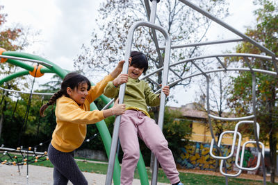 Two laughing girls turning around on playground