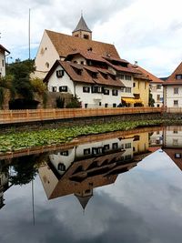 Reflection of building in puddle against sky