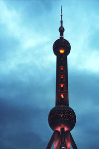 Low angle view of hand holding illuminated light against sky