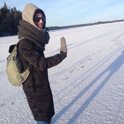 Side view of young man standing on snow covered field