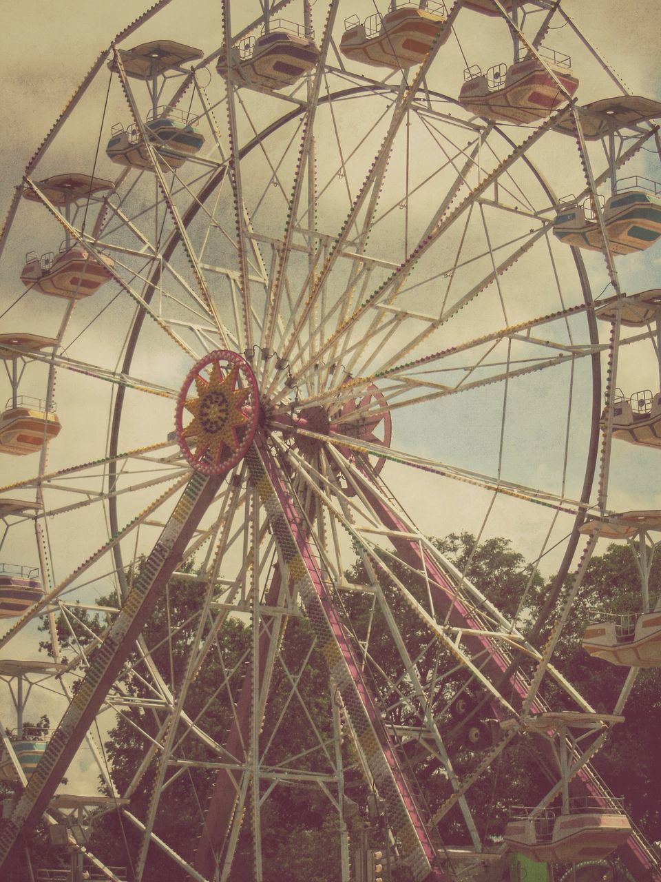 amusement park, amusement park ride, ferris wheel, low angle view, arts culture and entertainment, built structure, architecture, metal, sky, circle, no people, day, outdoors, pattern, ceiling, building exterior, metallic, wheel, decoration