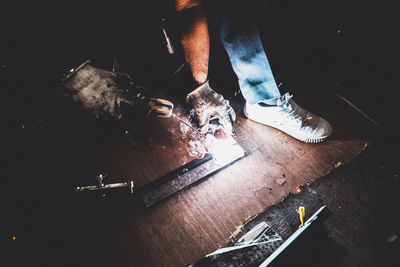 Low section of man standing on wooden floor