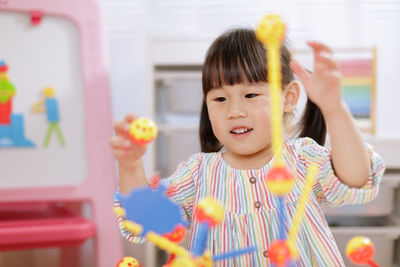 Cute girl playing with toy at home