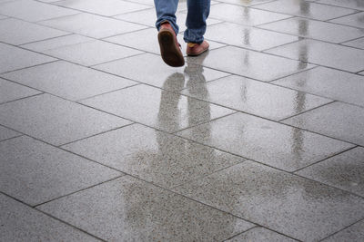 Low section of person standing on tiled floor