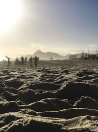 Surface level of beach against sky during sunset