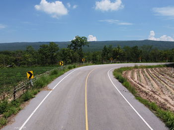 Road passing through landscape against sky