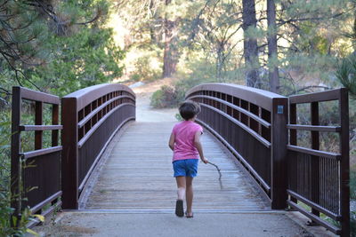 Young child running across a bridge