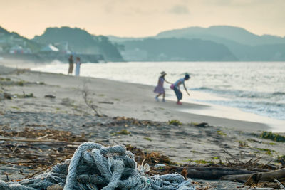 Close-up of fishing net on beach against sky