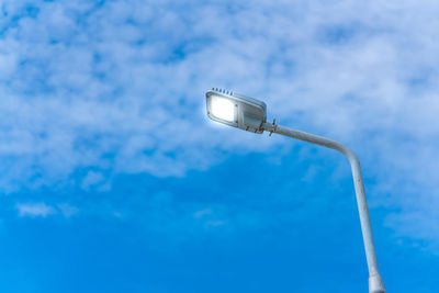 Low angle view of telephone pole against blue sky