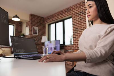 Midsection of woman using laptop at office