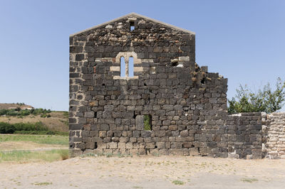 Old ruin building on field against clear sky