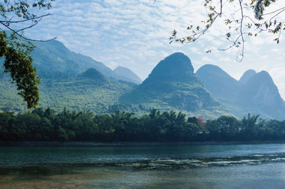 Scenic view of river and mountains against sky