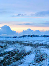 Scenic view of frozen lake against sky during sunset
