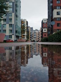 Reflection of buildings in canal against sky