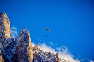 Low angle view of person against blue sky