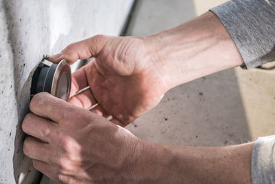 Cropped hands of man repairing pipe