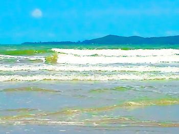 Scenic view of beach against blue sky