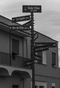 Low angle view of road sign against sky in city