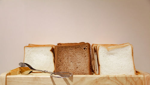 Close-up of bread on table against white background